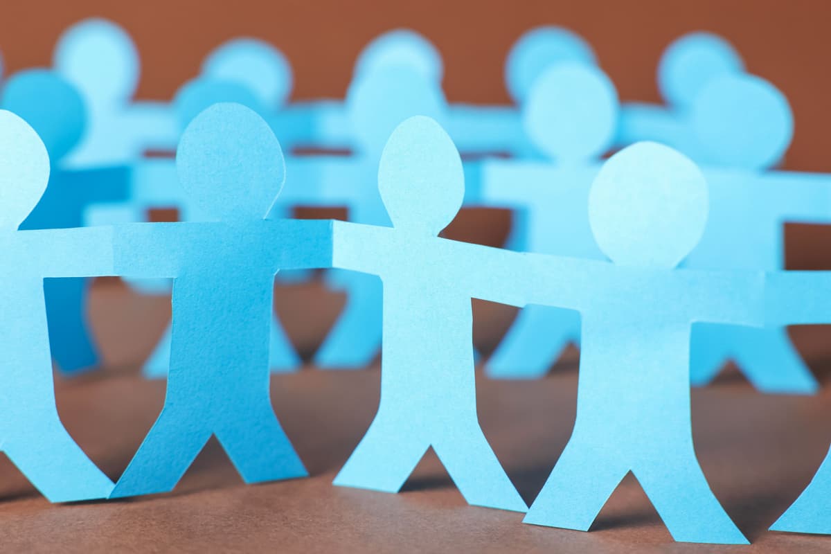 A paper chain of cutout figures holding hands