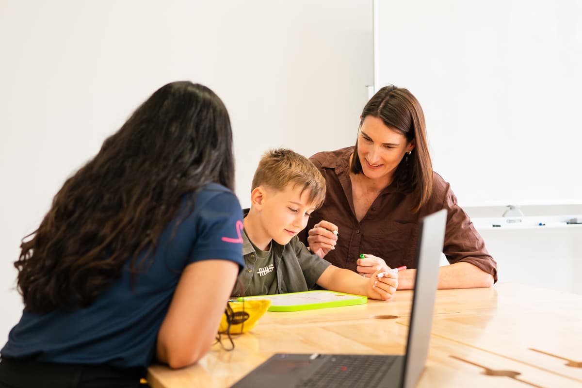 A clinician is meeting with a mum and her child at a desk